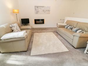 a living room with two couches and a tv at Primrose in Holsworthy