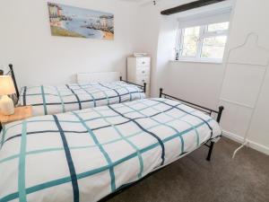 1 dormitorio con 2 camas y ventana en Primrose, en Holsworthy