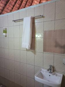 ein Bad mit einem Waschbecken und einem weißen Handtuch in der Unterkunft BN Private Beach in Jinja