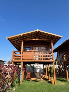 a large wooden house with a large deck at Pousada BANGALÔS SOL DE LAGOINHA in Lagoinha