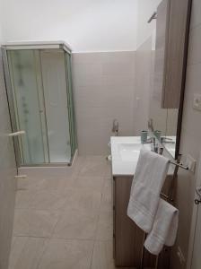 een badkamer met een wastafel en een glazen douche bij Casa Cesira in Casamassella