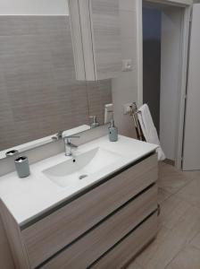 een badkamer met een witte wastafel en een spiegel bij Casa Cesira in Casamassella