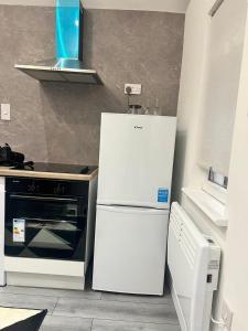 a white refrigerator in a kitchen next to a stove at AYOS in Dublin