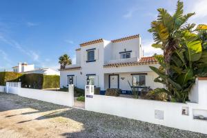 une maison blanche avec une clôture blanche dans l'établissement Casa Da Bauhinia, à Aljezur