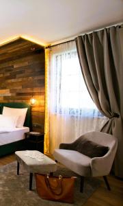 1 dormitorio con 1 cama, 1 silla y 1 ventana en B&B Plitvice Holiday Lodge, en Lagos de Plitvice
