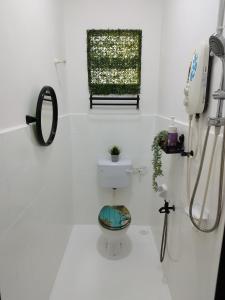 uma casa de banho branca com um WC e uma janela em Basrie Homestay Pagoh - Private Pool/W-ifi/NetFlix/Cozy em Pagoh