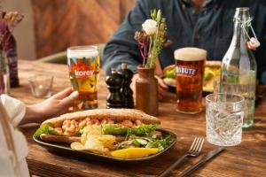 a wooden table with a plate of food and drinks at The Ship Inn in Mousehole