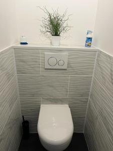 a bathroom with a toilet with a shelf above it at Appartement La Marina Deauville in Deauville