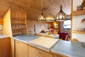uma cozinha com paredes de madeira e luzes pendentes em Wettersteinpanorama - a74054 em Mittenwald