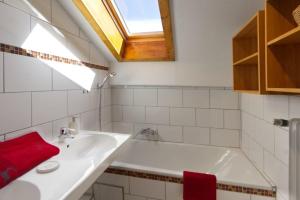 uma casa de banho com um lavatório branco e uma toalha vermelha em Wettersteinpanorama - a74054 em Mittenwald