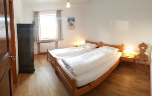 1 dormitorio con 1 cama grande y 2 lámparas en Ferienhaus Alpenbichl - a74010 en Krün