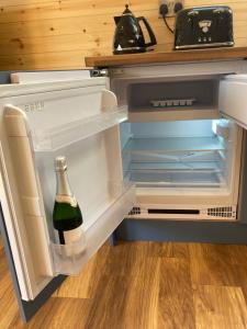 an open refrigerator with a bottle of wine in it at Laity's Lodge in Penzance