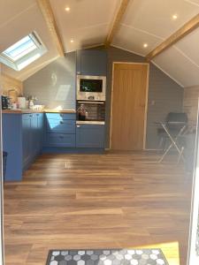 a kitchen with blue cabinets and a wooden floor at Laity's Lodge in Penzance