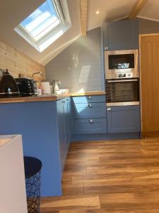 a kitchen with blue cabinets and a window at Laity's Lodge in Penzance