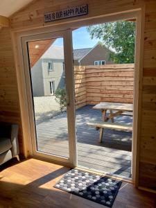 a sliding glass door in a cabin with a picnic table at Laity's Lodge in Penzance