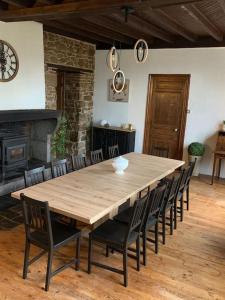 Gîte de Lafayette في Pionsat: وجود طاولة وكراسي خشبية كبيرة في الغرفة