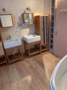 a bathroom with two sinks and a mirror at Gîte de Lafayette in Pionsat