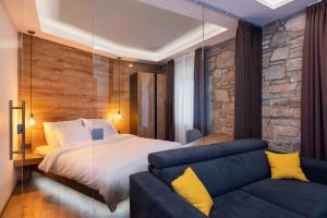科佩爾的住宿－Štok - Rooms, Wine & Restaurant - Marezige, Koper，一间卧室配有一张大床和一张沙发