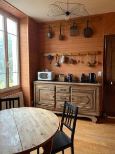 a kitchen with a table and a counter with a microwave at Gîte de Lafayette in Pionsat