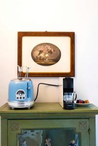 a toaster and a toaster on a table with a picture at Dama charming apartment 100m from Piazza del Campo in Siena +4 photos