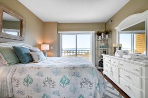 ein Schlafzimmer mit einem Bett, einer Kommode und einem Fenster in der Unterkunft Playa Flamingo #302 in Ocean City