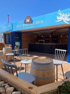 a group of chairs and tables and barrels in front of a bar at Marine Holiday Park D & S rental A in Rhyl