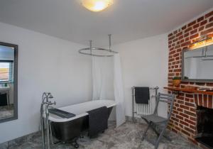 Cette chambre dispose d'une baignoire, d'une chaise et d'une télévision. dans l'établissement Trinity Square, Margate, à Kent