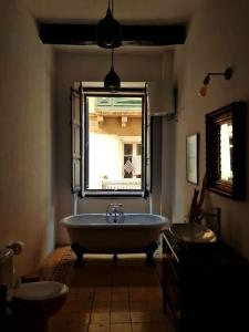 La salle de bains est pourvue d'une baignoire, d'une fenêtre et d'un lavabo. dans l'établissement Grand House of Character Valletta, à Il-Furjana