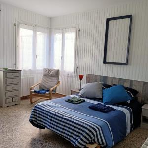 a bedroom with a bed and a chair and window at Studio Calme in Ouistreham