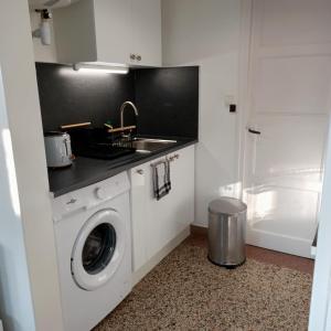 een keuken met een wasmachine en een wastafel bij Studio Calme in Ouistreham