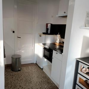 een kleine keuken met witte kasten en een fornuis bij Studio Calme in Ouistreham