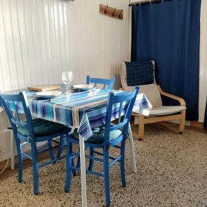 een eettafel met stoelen en een blauwe tafelkleed bij Studio Calme in Ouistreham