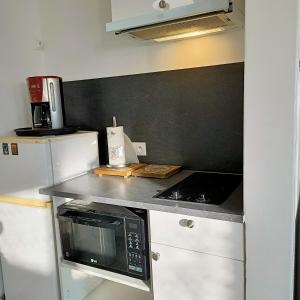 a kitchen with a counter top with a microwave at Studio Calme in Ouistreham