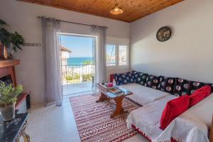 a living room with a couch and a view of the ocean at Fantasea Apartments in Stómion