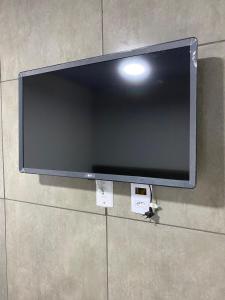 TV de pantalla plana colgada en la pared en GYN SUITES - SUITES EM GOIÂNIA GO, en Goiânia