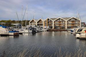 a marina with boats docked in front of a large building at Luxe loft appartement in Résidence Marina Kamperland (8 pers.) in Kamperland