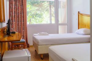 um quarto com 2 camas, uma secretária e uma janela em Hotel NAVI em Shabla