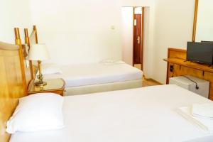 um quarto de hotel com duas camas e uma televisão em Hotel NAVI em Shabla