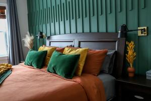 a bedroom with a bed with green and orange pillows at Spa, piscine et plein air au Mont Blanc in Mont-Blanc