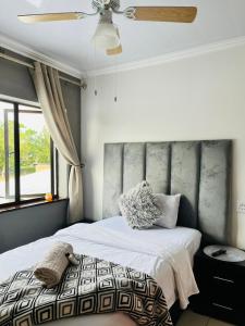 a bedroom with a bed and a ceiling fan at Abecor Hotel in Welkom