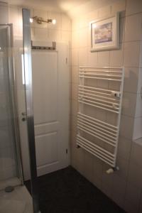 a bathroom with a shower and a white door at Yachthafenresidenz-Wohnung-9301-898 in Kühlungsborn