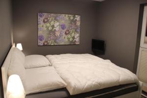 キュールングスボルンにあるYachthafenresidenz-Wohnung-9301-898の白いベッドが備わる壁画のあるベッドルームです。