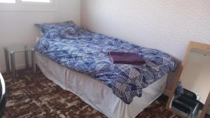 a bed with a blue and white comforter in a room at Lesley House in Bridgwater