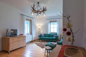 un salon avec un canapé bleu et une télévision dans l'établissement Das Haus in Altaussee, à Altaussee