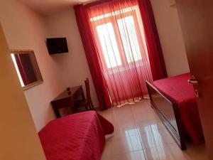 クザーノ・ムトリにあるIl Conventoの赤いベッドと赤い窓が備わるベッドルーム1室が備わります。