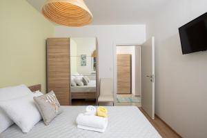 1 dormitorio con cama blanca y espejo en Apartment J&E, en Medulin