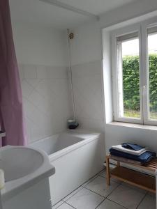 biała łazienka z wanną i oknem w obiekcie Gîte l'hirondelle w mieście Flers-lez-Lille