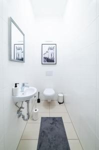 ein weißes Bad mit einem Waschbecken und einem WC in der Unterkunft Beautiful apartment in Vienna's heart 1b in Wien