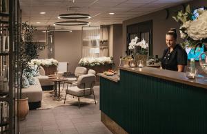 a woman standing at a counter in a salon at Fritiden Hotell & Kongress in Ystad
