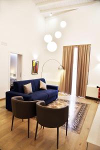 uma sala de estar com um sofá azul e cadeiras em Dimorae houses em Caltanissetta